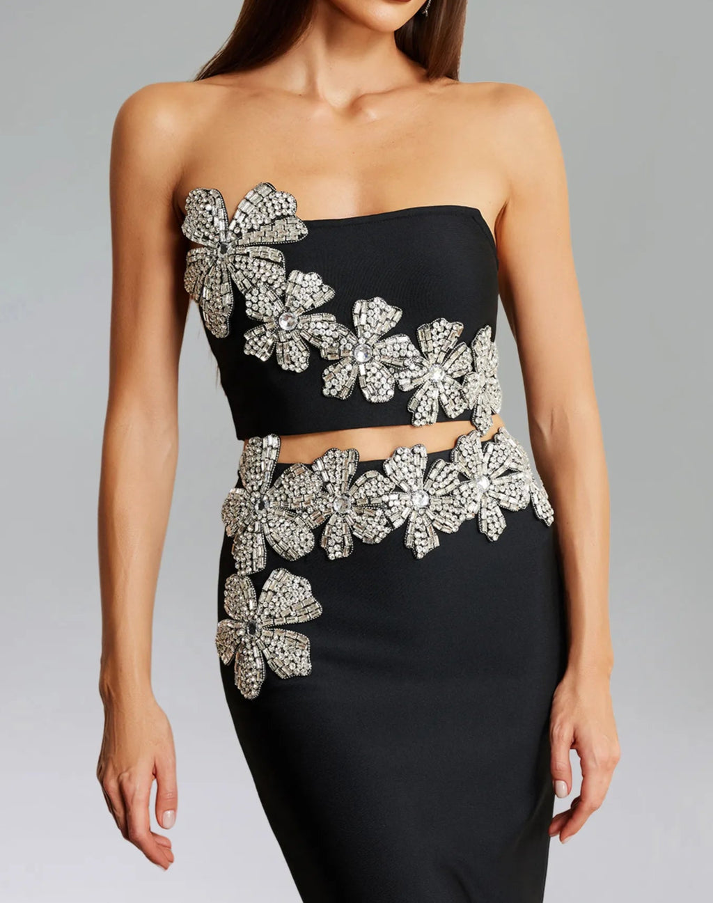 Black strapless top with silver floral embellishments on a gray background