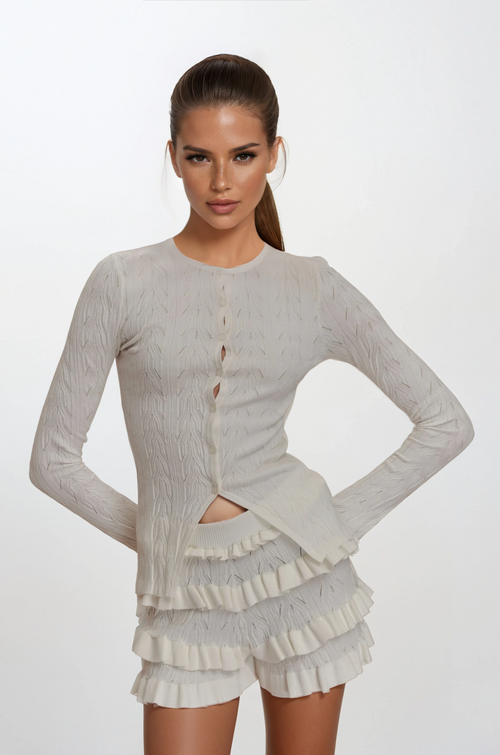 Woman wearing a light gray long-sleeve top and shorts on a white background