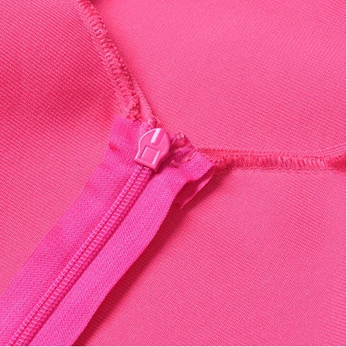 Close-up of pink fabric with zipper on a gray background