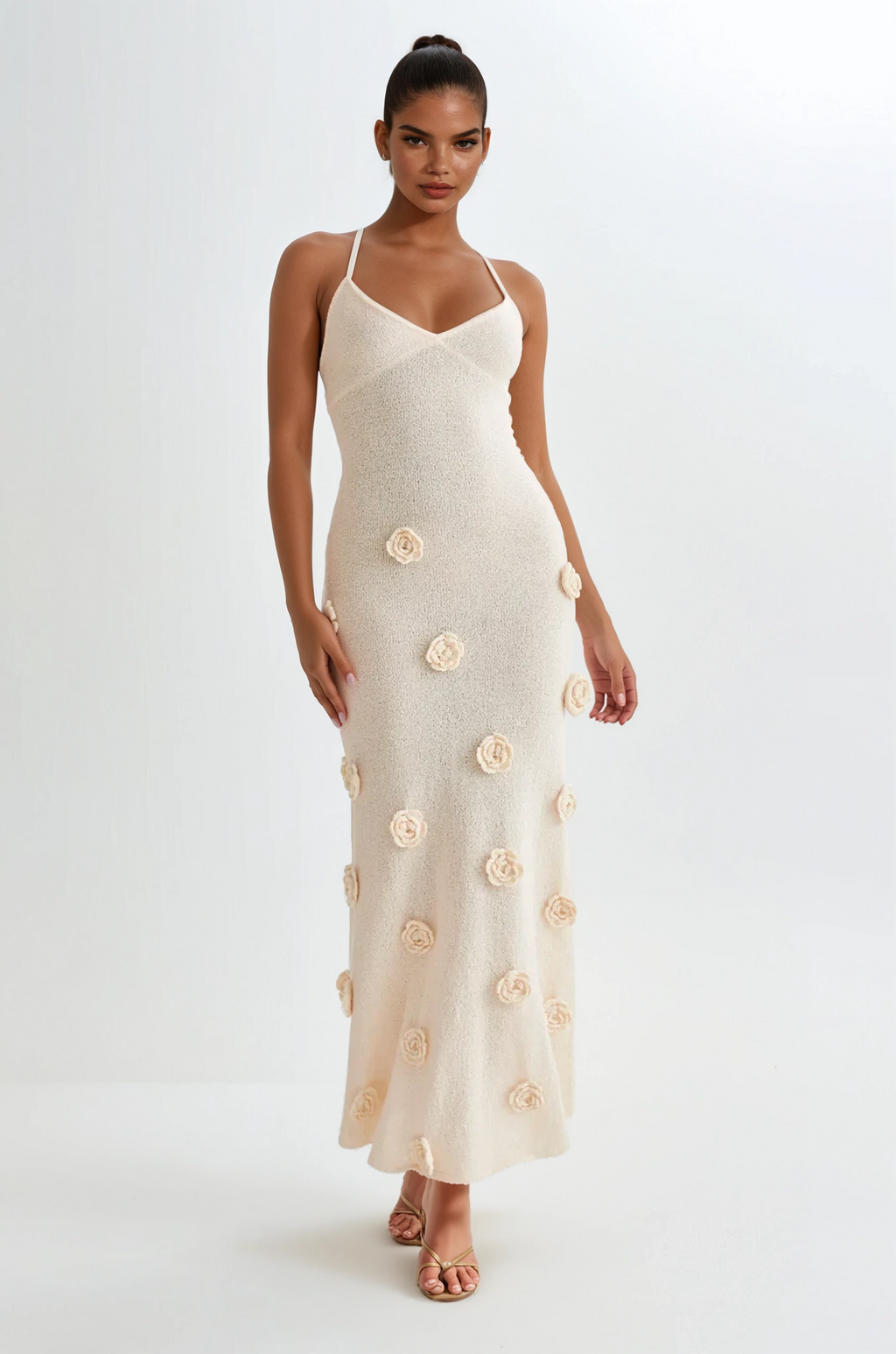 Woman wearing a white dress with floral embellishments on a white background