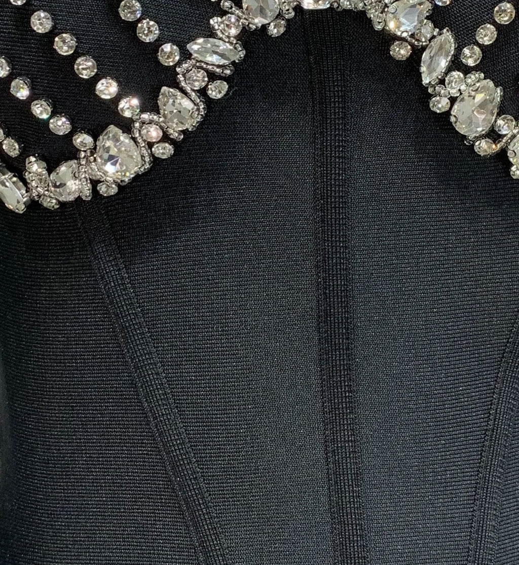 Black dress with a decorative beaded neckline on a mannequin against a white background