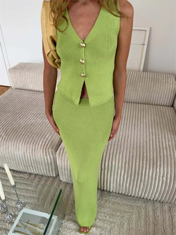 Person wearing a green knitted outfit with a white wall and beige sofa in the background