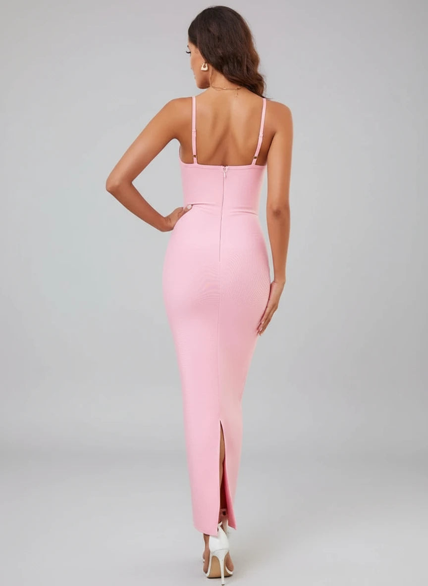 Woman wearing a pink dress with a high slit in a living room setting.