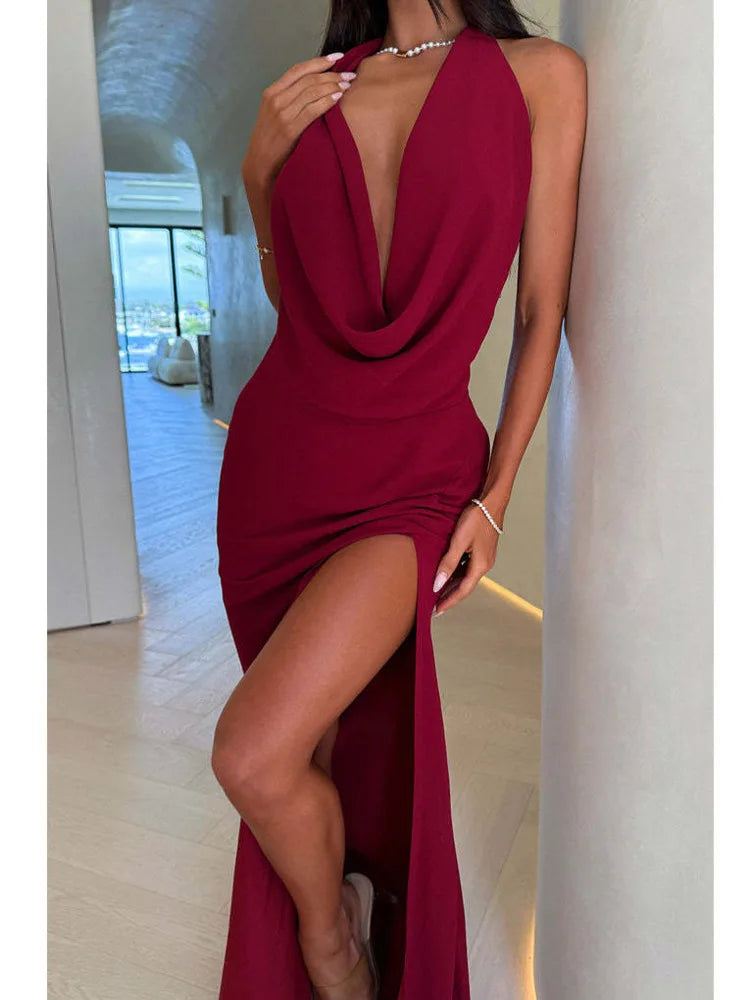 Woman wearing a burgundy evening gown with a high slit in an indoor setting.