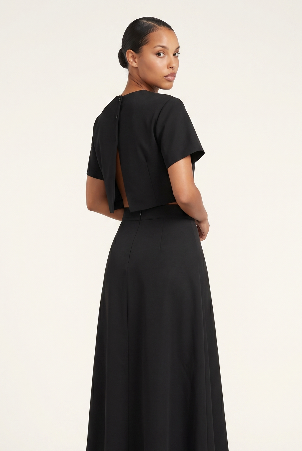 Woman wearing a black dress with a plain background
