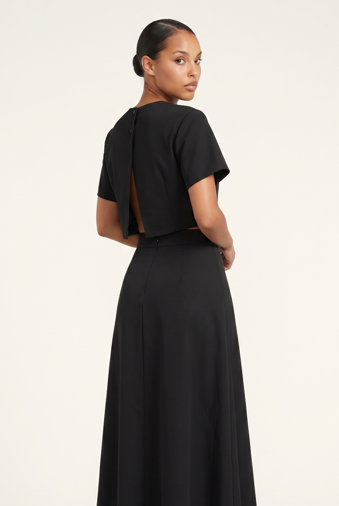 Woman wearing a black dress with a plain background